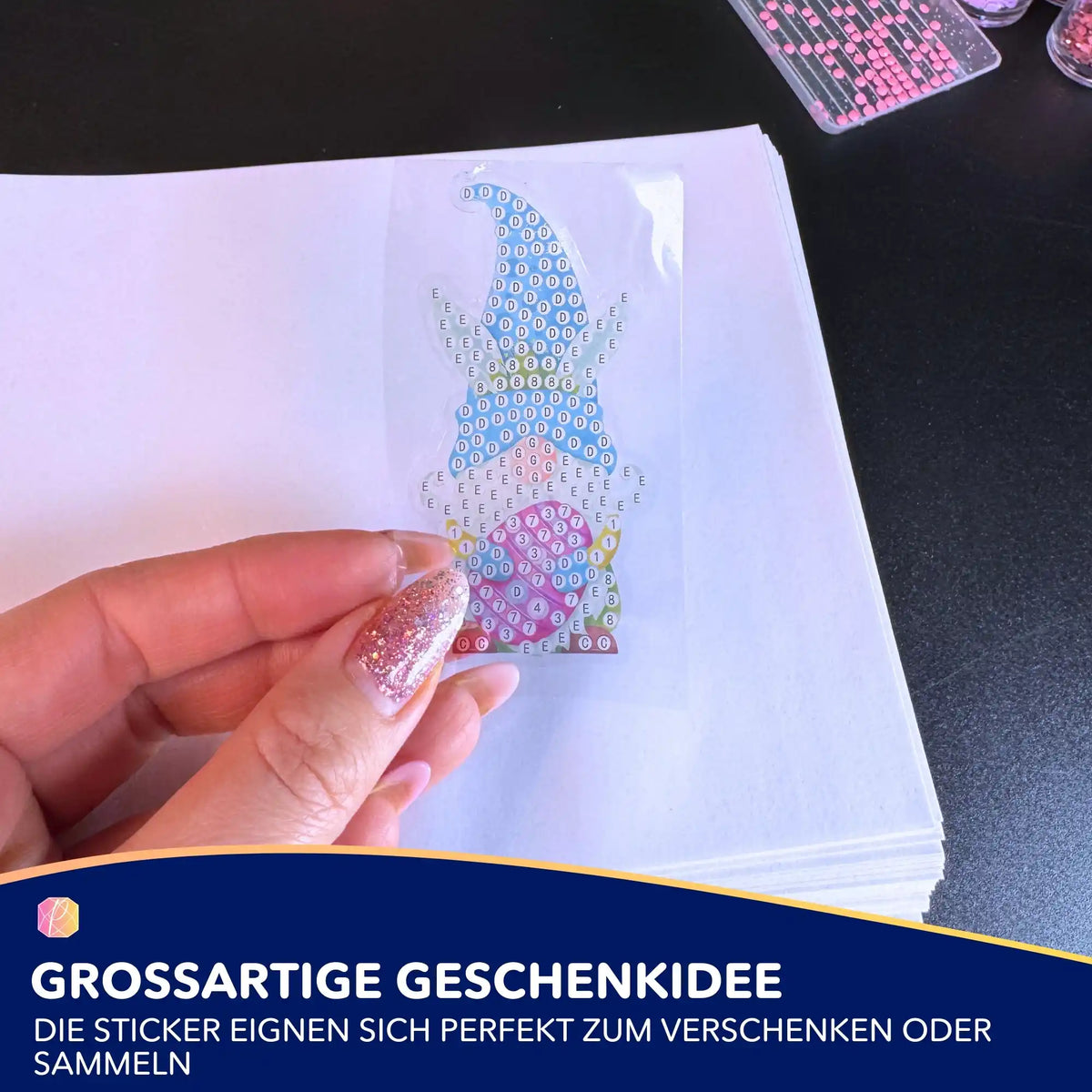 Hand hält Diamond Painting Oster-Sticker mit Zwergen-Motiv auf einer weißen Vorlage für kreatives Oster-Basteln