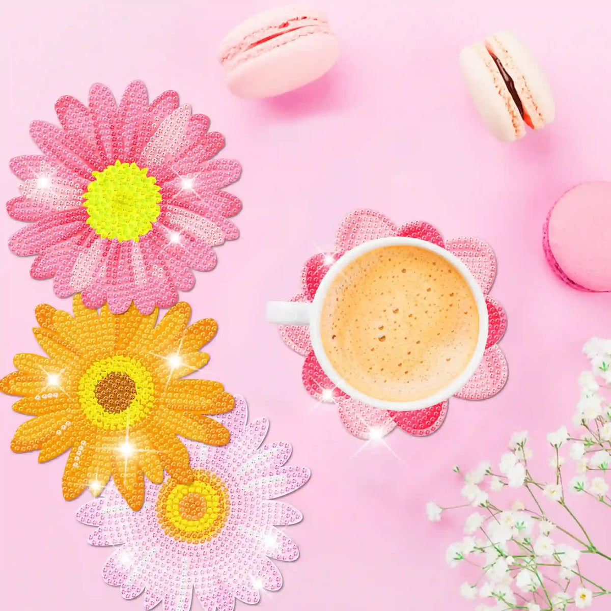 Diamond Painting Untersetzer Set Blume mit glitzernden Steinen auf rosa Hintergrund mit Kaffee und Macarons dekoriert.