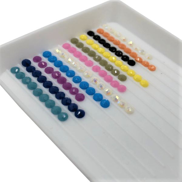 Bunte Diamond Painting Steine sortiert in einer weißen Riffelschale für dekorative Sticker Projekte